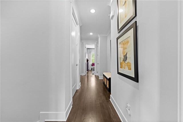 hall featuring recessed lighting, dark wood-style flooring, crown molding, and baseboards