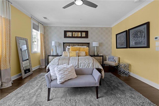 bedroom with wallpapered walls, baseboards, dark wood finished floors, an accent wall, and ornamental molding