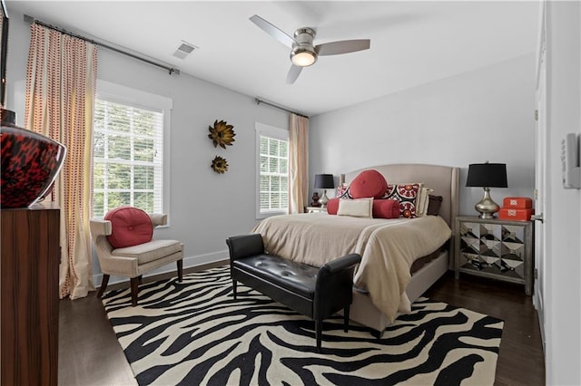 bedroom featuring baseboards, visible vents, a ceiling fan, and dark wood-style flooring