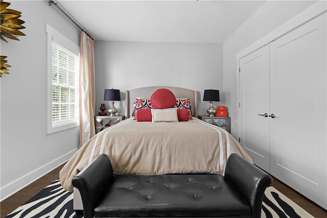 bedroom with dark wood-style flooring and baseboards