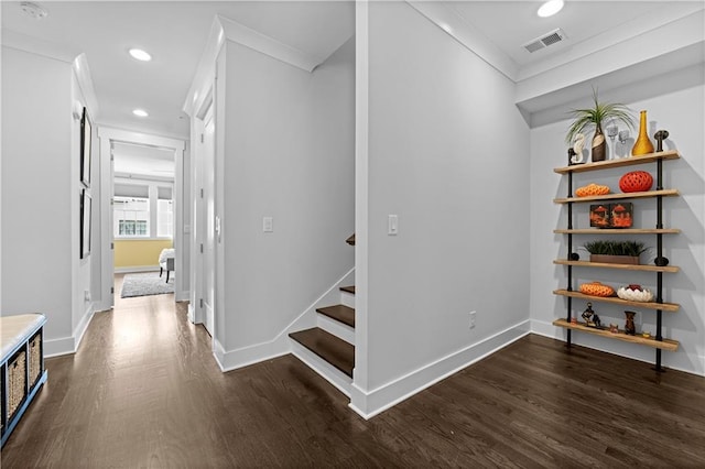 interior space with dark wood-style floors, ornamental molding, visible vents, and baseboards