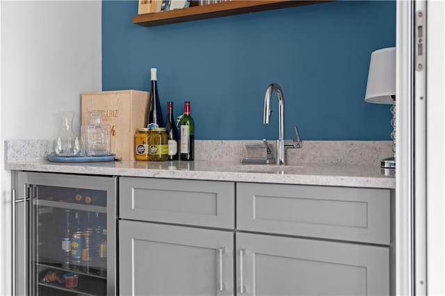 bar featuring wine cooler, indoor bar, and a sink