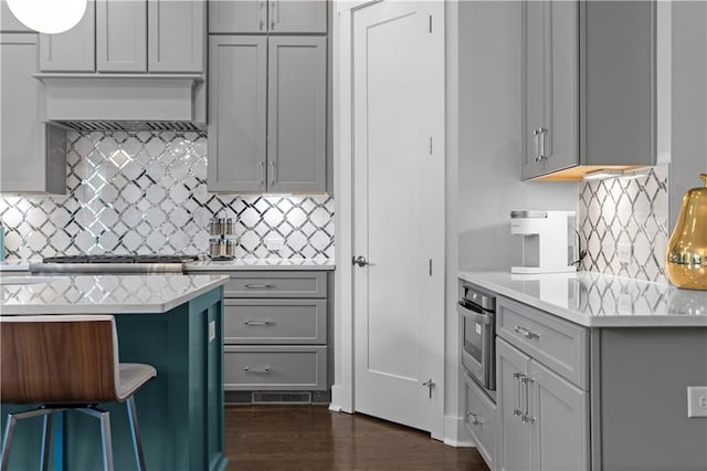 kitchen featuring gray cabinets, light countertops, and stainless steel oven