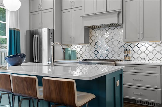 kitchen featuring a breakfast bar, light countertops, and high end fridge