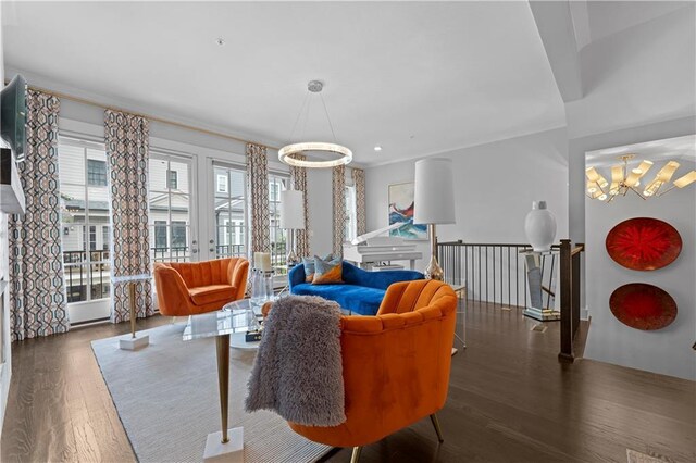 sitting room with a chandelier, dark wood-type flooring, and an upstairs landing