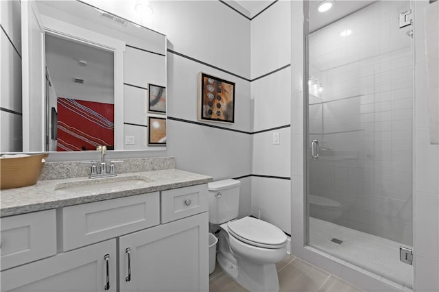 full bathroom featuring toilet, visible vents, vanity, and a stall shower