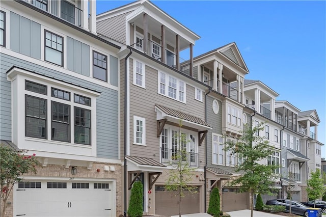 townhome / multi-family property featuring board and batten siding, a standing seam roof, metal roof, and a garage