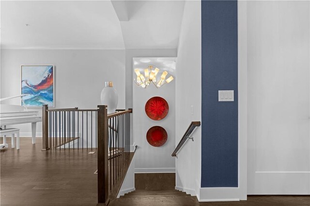 stairs with a notable chandelier, baseboards, and wood finished floors