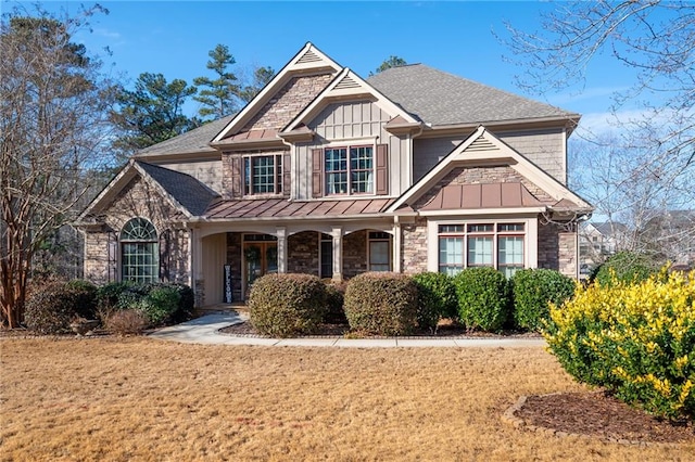 craftsman-style home featuring covered porch and a front lawn