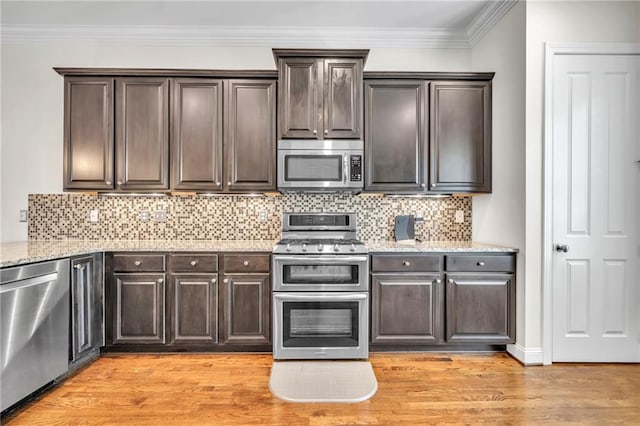 kitchen with light wood-style floors, light stone countertops, appliances with stainless steel finishes, and dark brown cabinetry