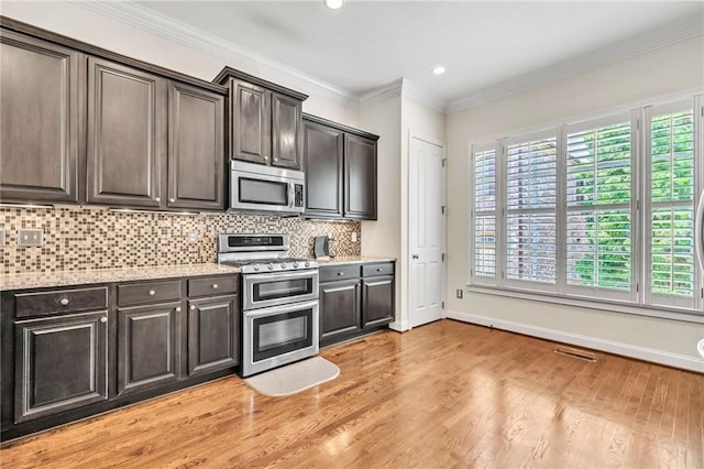 kitchen with stainless steel appliances, light wood-style floors, light stone countertops, baseboards, and decorative backsplash