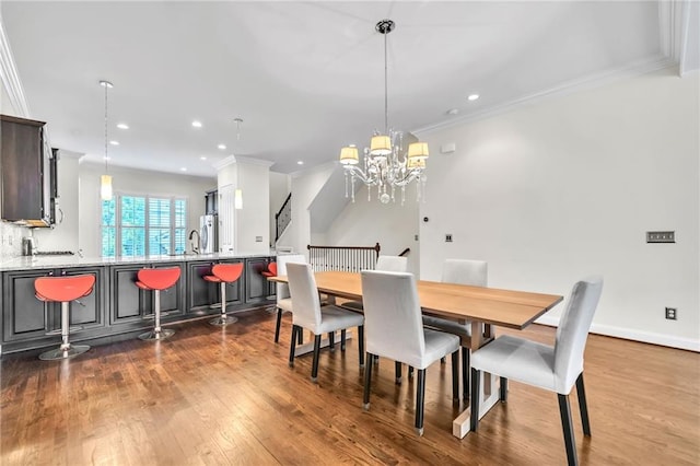 dining area with a notable chandelier, crown molding, dark wood-type flooring, and recessed lighting