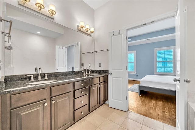 bathroom featuring double vanity, ensuite bath, tile patterned flooring, and a sink