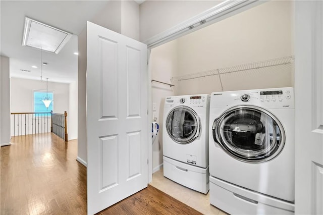 washroom featuring washing machine and clothes dryer, attic access, recessed lighting, wood finished floors, and laundry area