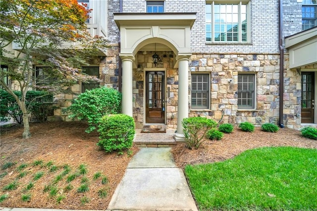doorway to property with stone siding and brick siding