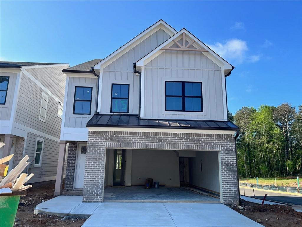1075 Crest Mill Dr, Marietta, GA 30008 - view of front of home with brick siding, concrete driveway, board and batten siding, a standing seam roof, and an attached garage