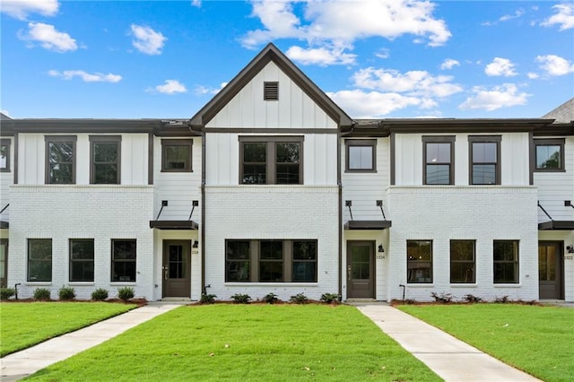 townhome / multi-family property featuring a front yard