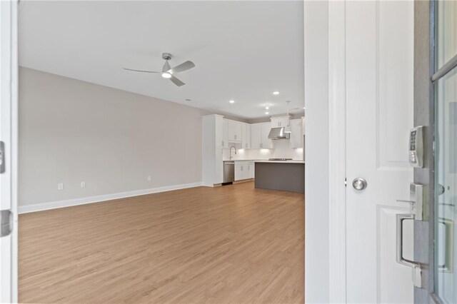 unfurnished living room featuring light hardwood / wood-style flooring and ceiling fan