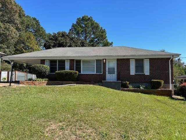 single story home with a front yard and a carport