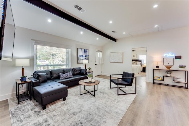 living room with light hardwood / wood-style floors and vaulted ceiling with beams