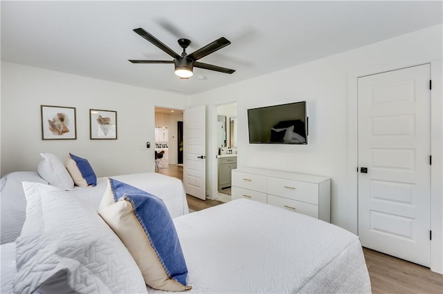 bedroom with ensuite bathroom, light hardwood / wood-style flooring, and ceiling fan