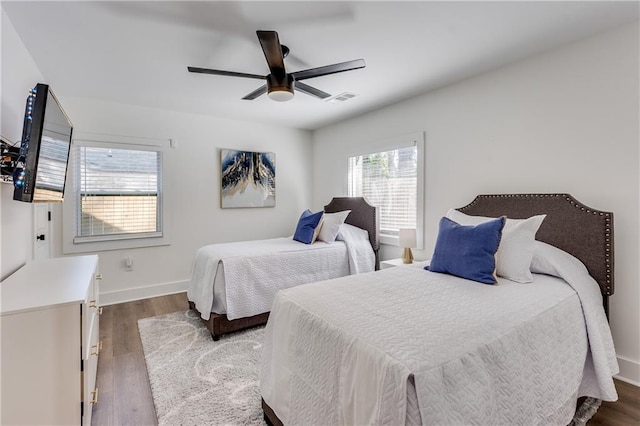 bedroom with dark hardwood / wood-style flooring and ceiling fan