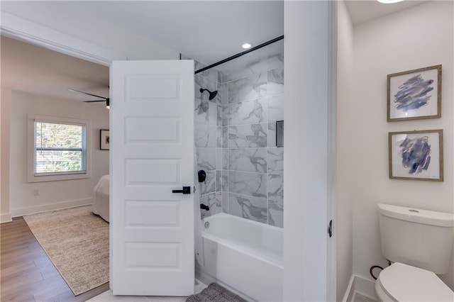 bathroom featuring hardwood / wood-style flooring, ceiling fan, toilet, and tiled shower / bath combo