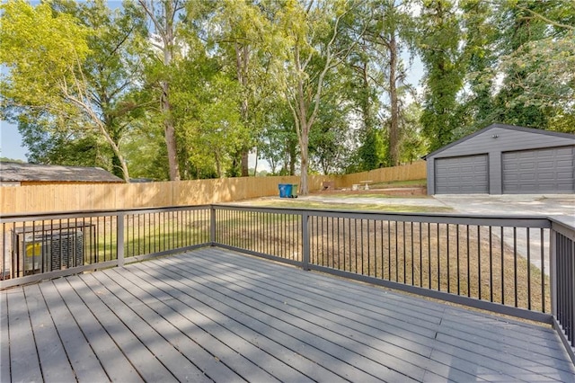 wooden deck featuring a garage and an outbuilding