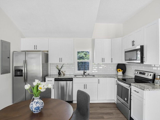 3100 Mount Gilead Rd SW, Atlanta, GA 30311 - kitchen featuring appliances with stainless steel finishes, lofted ceiling, light stone counters, backsplash, and white cabinetry