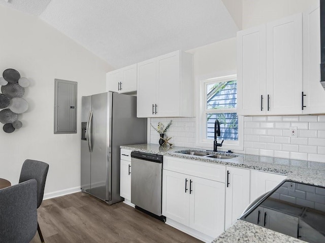3100 Mount Gilead Rd SW, Atlanta, GA 30311 - kitchen with stainless steel appliances, electric panel, vaulted ceiling, decorative backsplash, and light stone counters