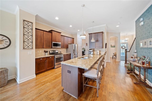 entryway with a wealth of natural light, light hardwood / wood-style flooring, and ornamental molding