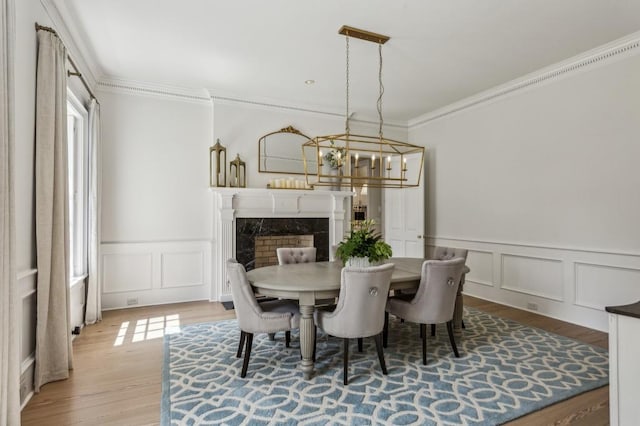 2671 Bohler Rd NW, Atlanta, GA 30327 - dining room with ornamental molding, a chandelier, a decorative wall, wood finished floors, and wainscoting