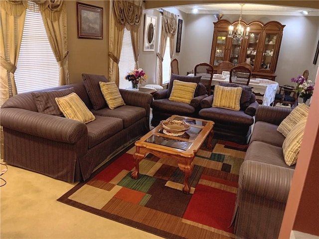 carpeted living room featuring a chandelier and ornamental molding