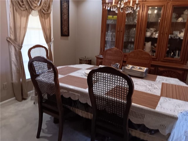 carpeted dining room with an inviting chandelier