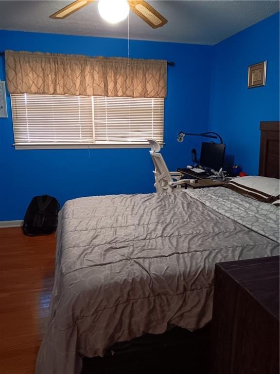 unfurnished bedroom with ceiling fan and wood-type flooring