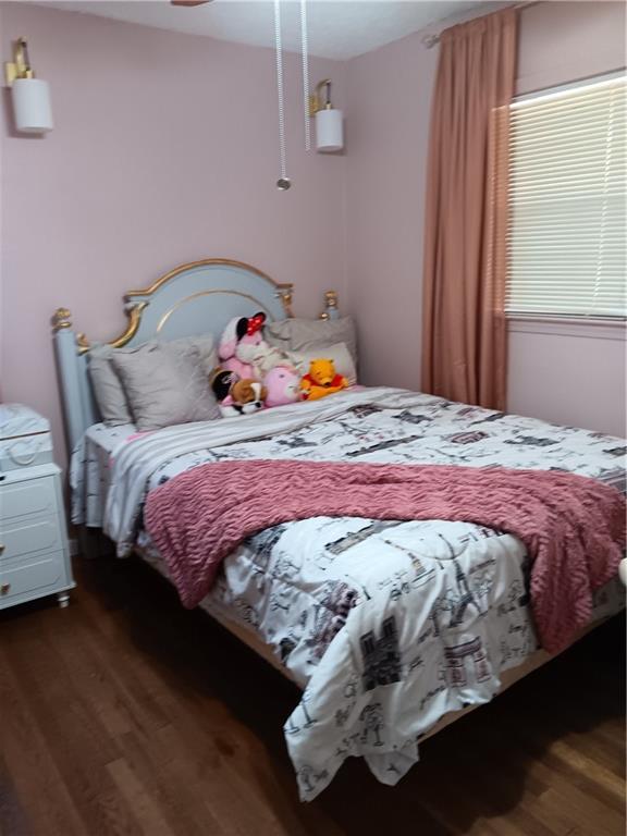 bedroom with dark hardwood / wood-style flooring