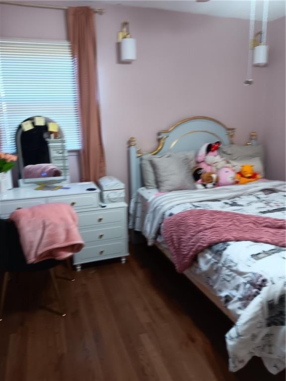 bedroom with dark hardwood / wood-style flooring