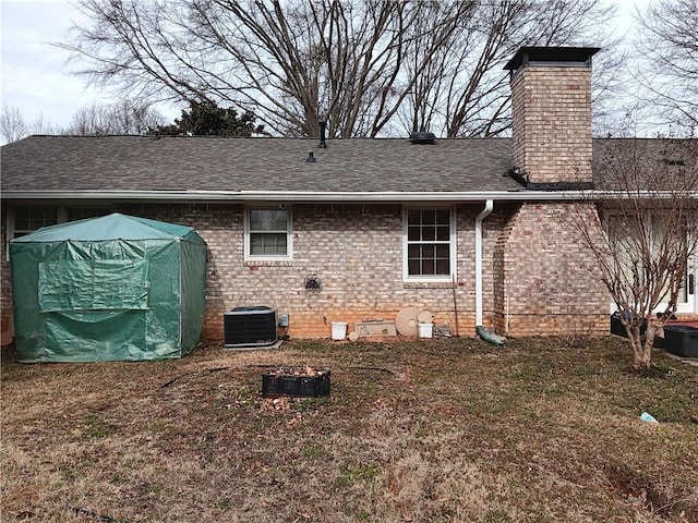 2479 Kingsland Dr, Dunwoody, GA 30360 - rear view of house featuring central AC, a chimney, brick siding, and roof with shingles
