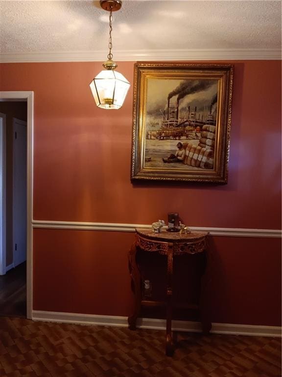 hall with a textured ceiling and ornamental molding