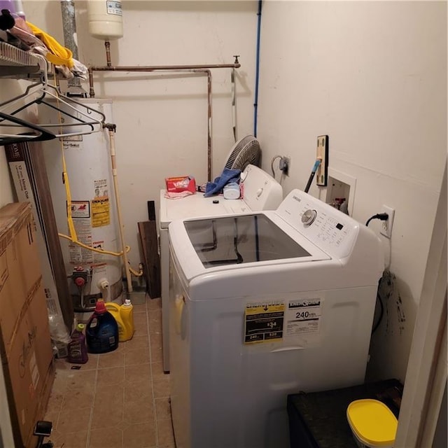 clothes washing area featuring tile patterned flooring, laundry area, water heater, and washer and clothes dryer