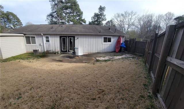 back of property with cooling unit, board and batten siding, and a fenced backyard