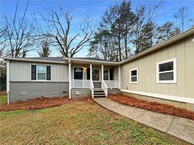 ranch-style house with covered porch and a front lawn