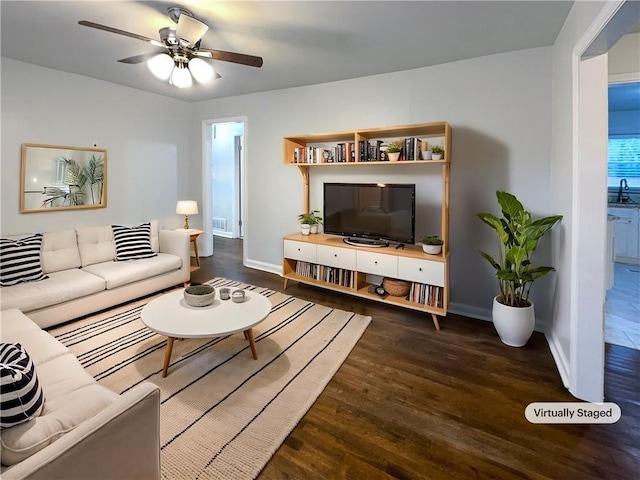 living room with dark wood-type flooring and ceiling fan