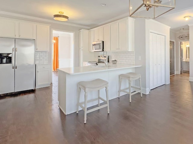 kitchen with crown molding, stainless steel appliances, and dark wood-type flooring