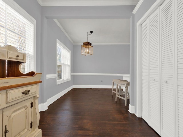 hallway featuring crown molding, baseboards, a notable chandelier, and dark wood-style floors