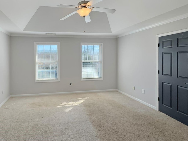 empty room with baseboards, visible vents, light carpet, and a raised ceiling