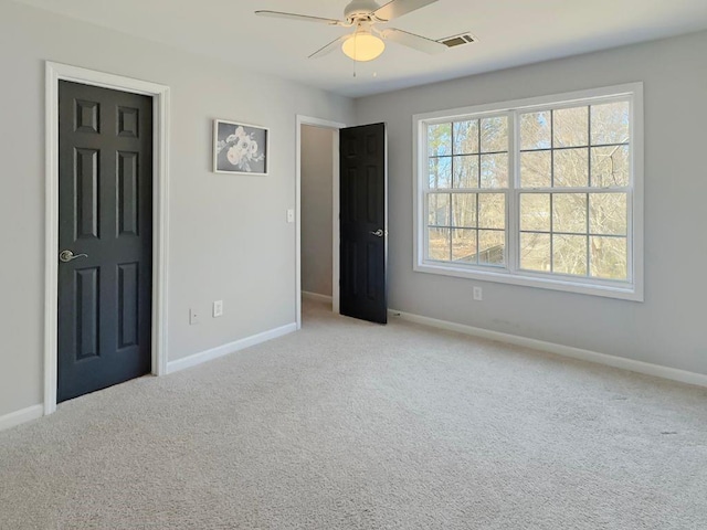 unfurnished bedroom featuring light colored carpet, baseboards, and visible vents
