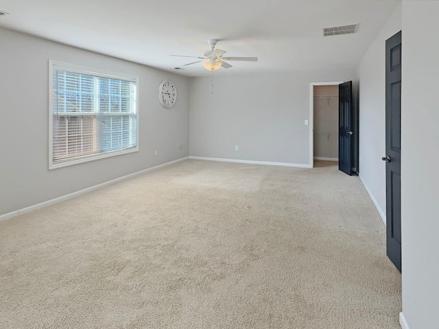 unfurnished room featuring a ceiling fan, baseboards, visible vents, and light carpet