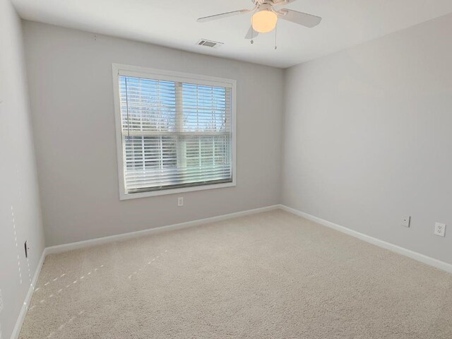 empty room featuring baseboards, ceiling fan, carpet, and visible vents