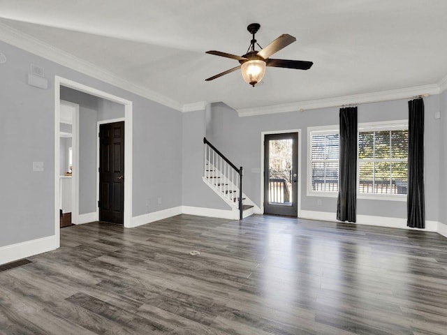 unfurnished living room featuring crown molding, dark wood-style flooring, a ceiling fan, and stairway